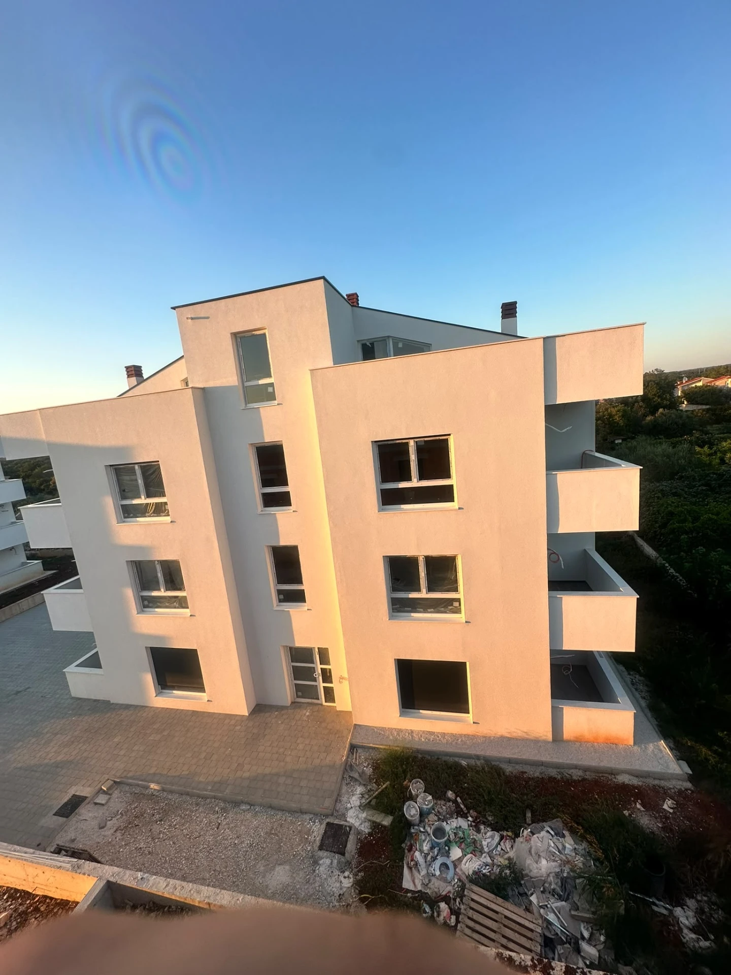 Apartment building seen from an upper terrace at golden hour
